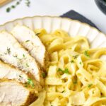 Up close view of sliced chicken with fettuccine alfredo