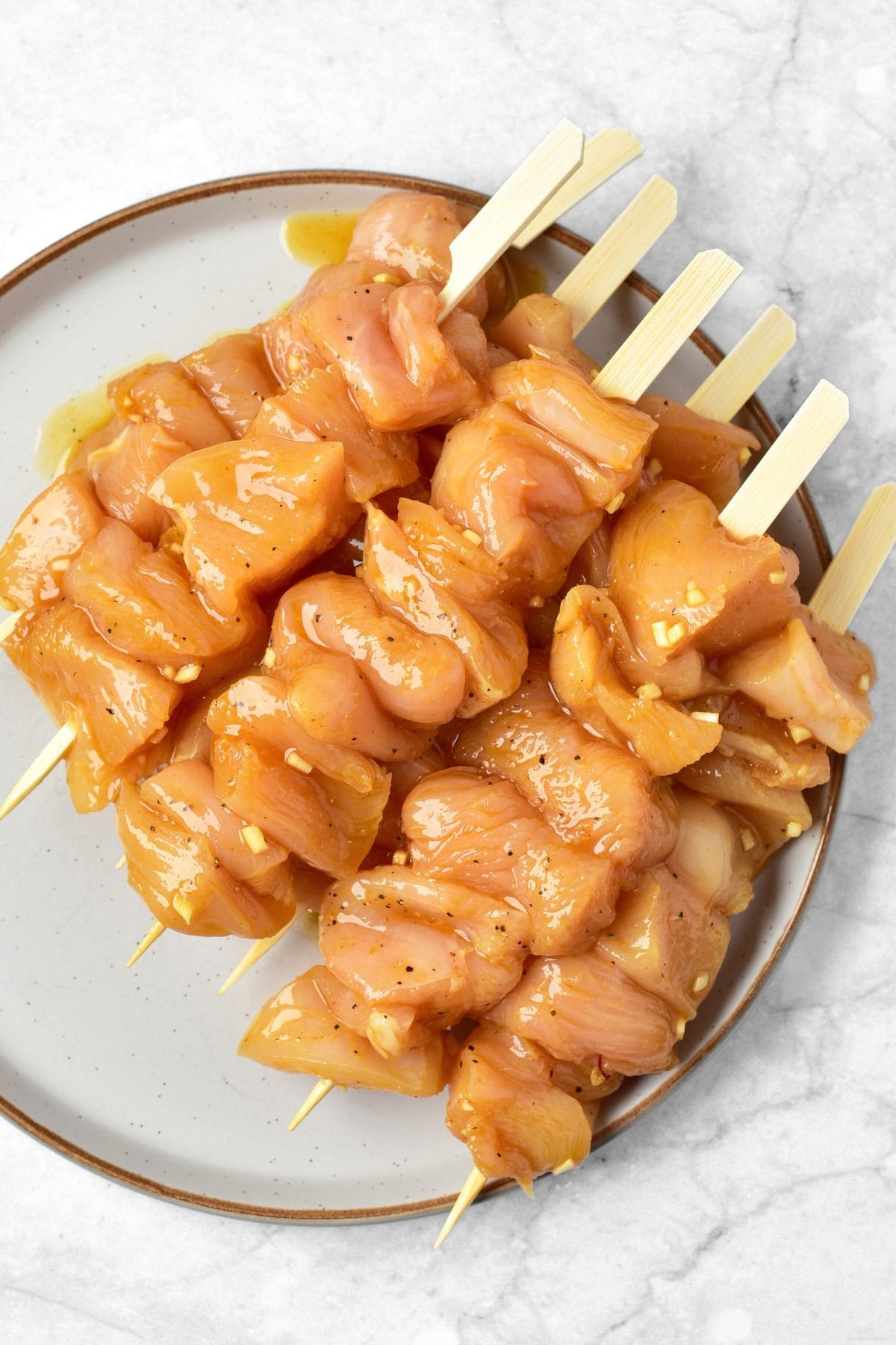 Marinated raw chicken pieces on skewers