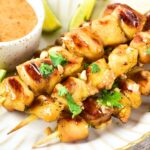 Chicken satay and peanut sauce on plate.