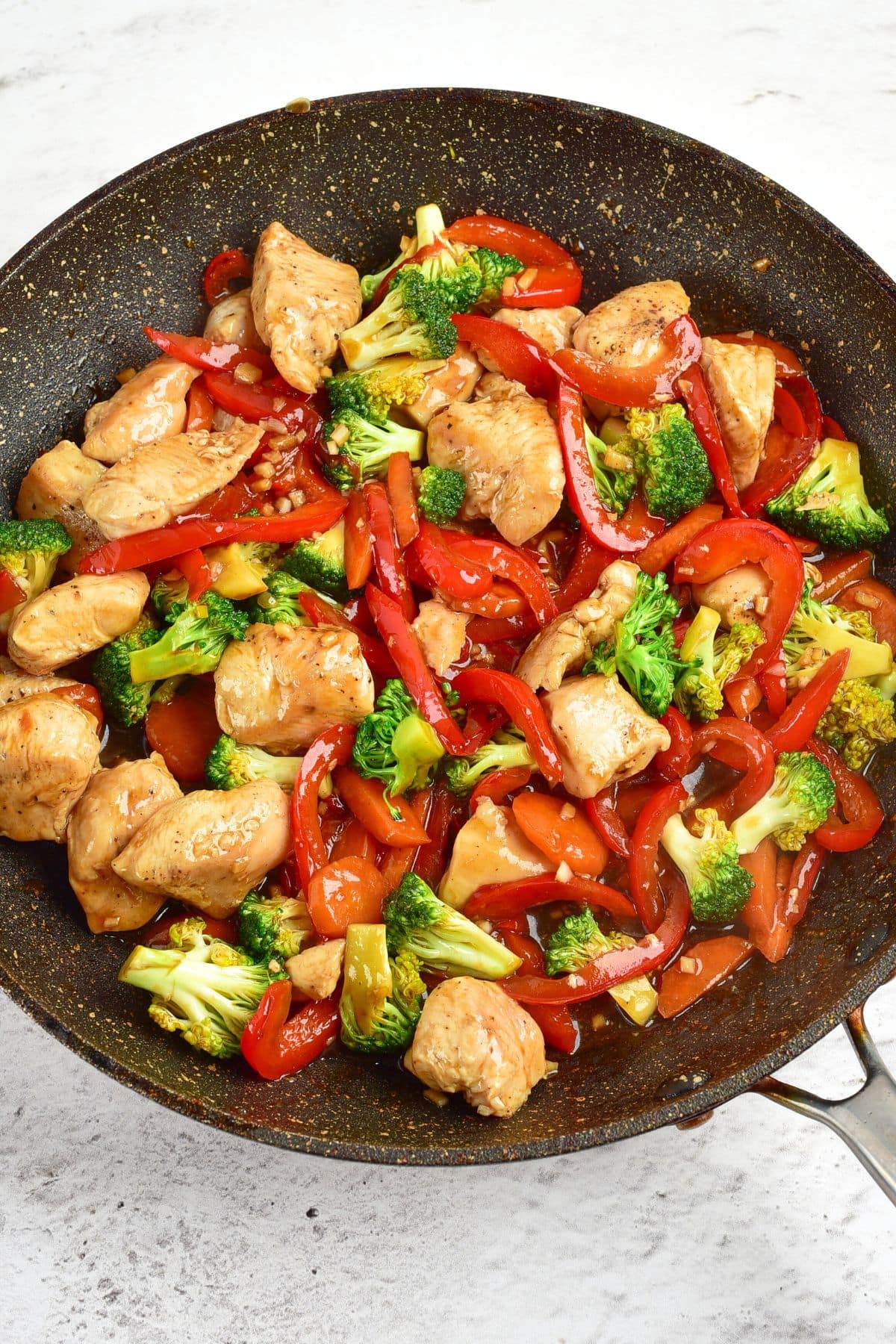 Top down view of chicken vegetable stir fry in skillet