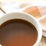 A bowl of caramel sauce surrounded by graham crackers