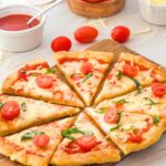 Sliced pizza on wooden board