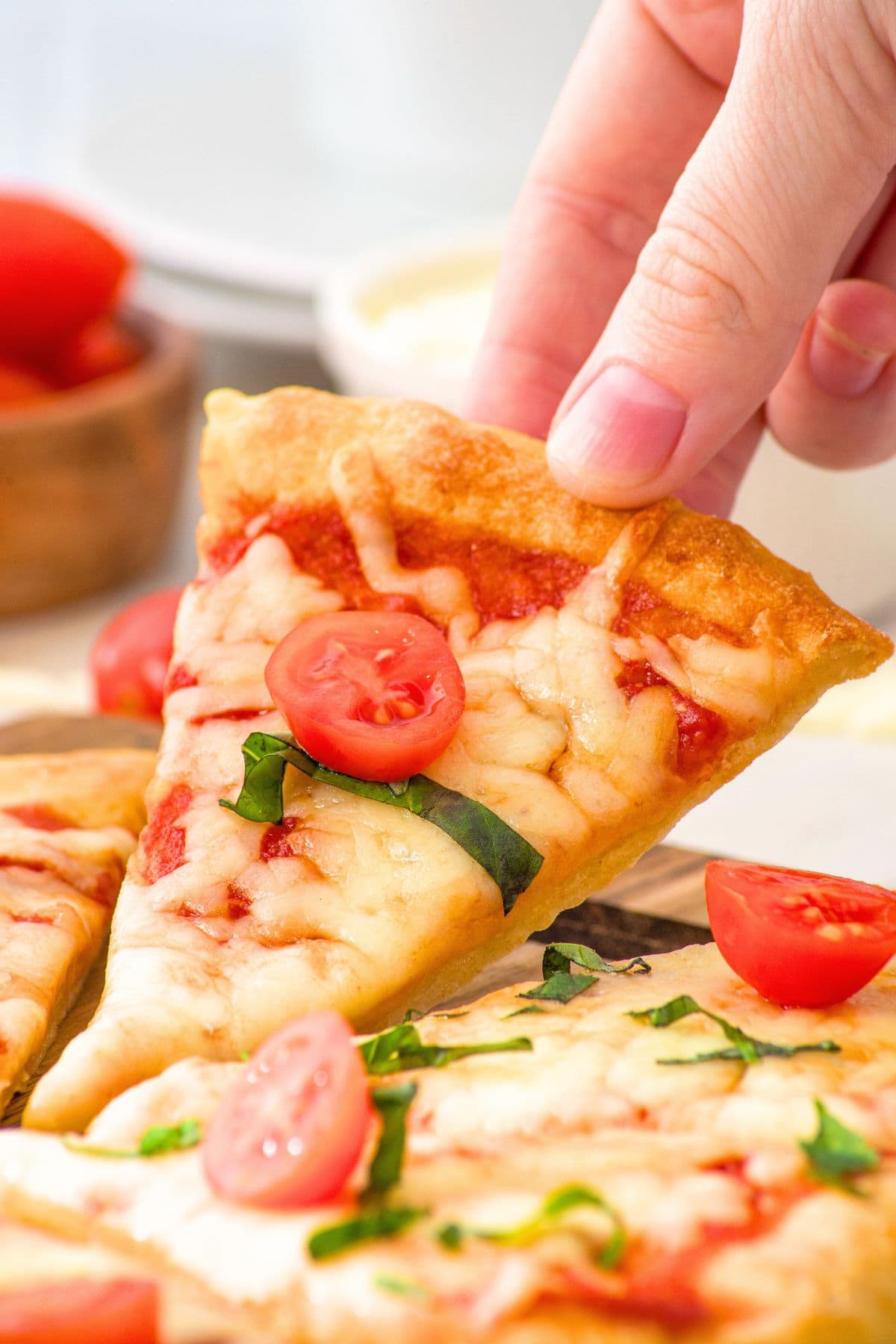 Hand holding up a slice of pizza
