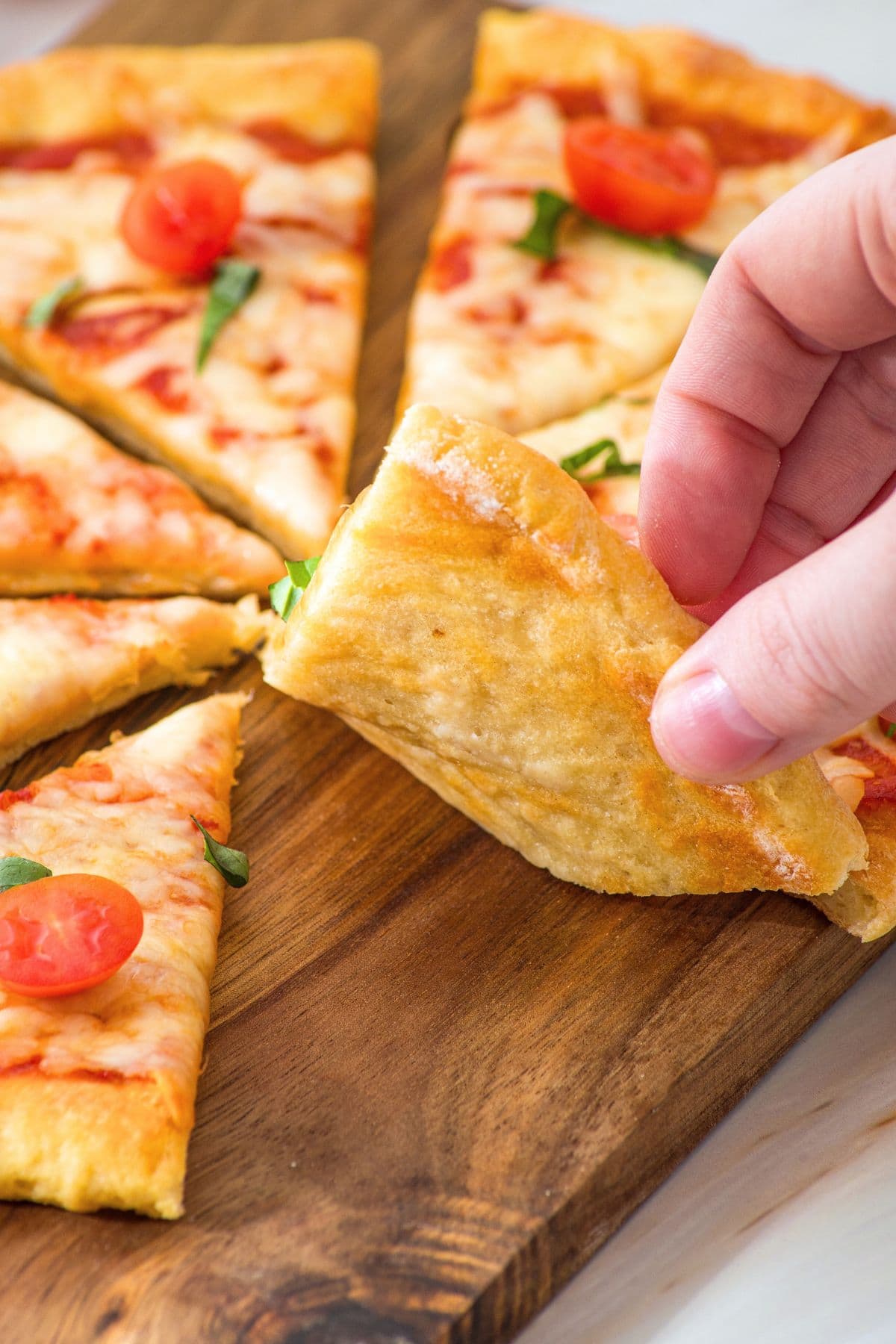 Hand reaching for a slice of cottage cheese pizza