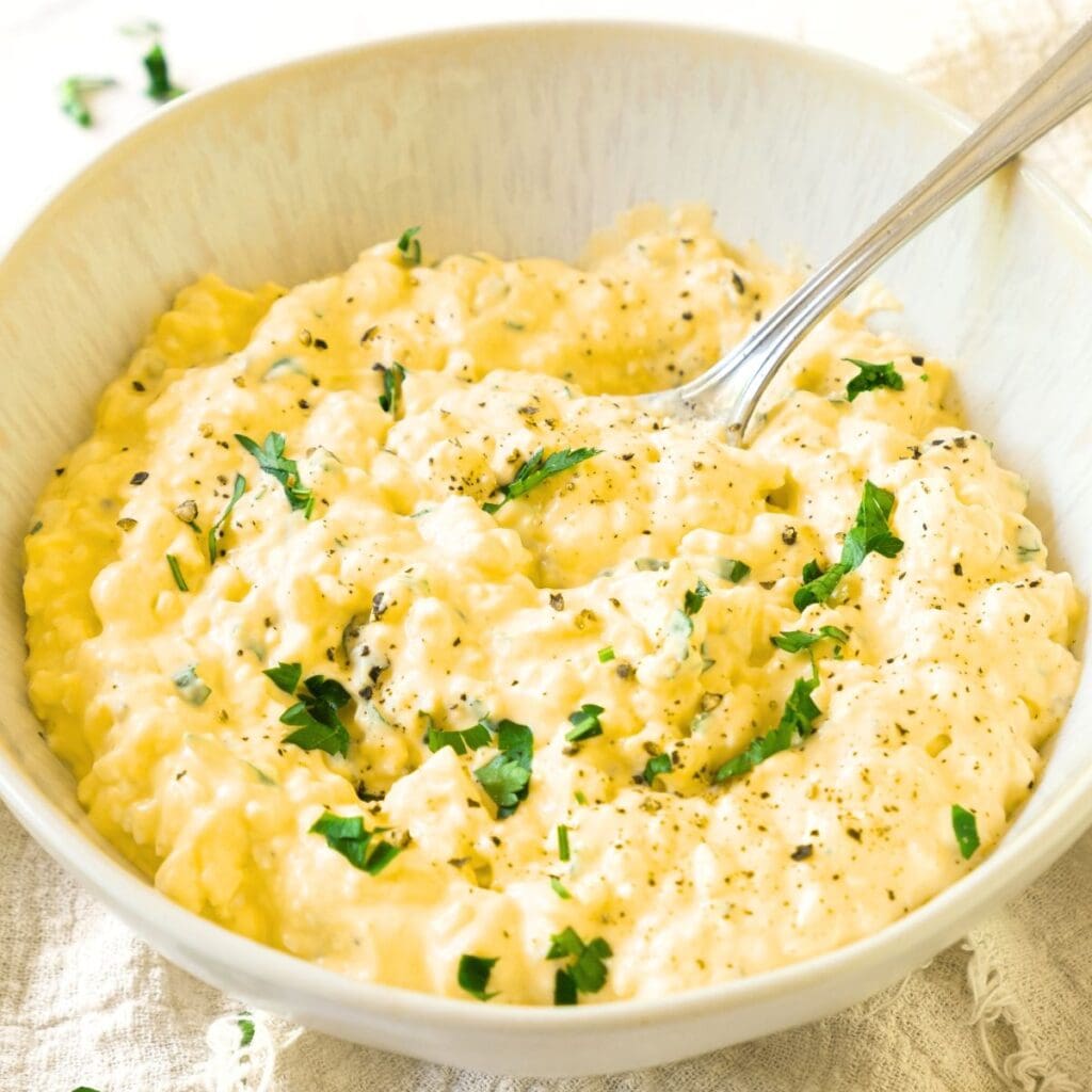 A spoon in a bowl of egg salad.