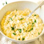 A spoon in a bowl of egg salad.