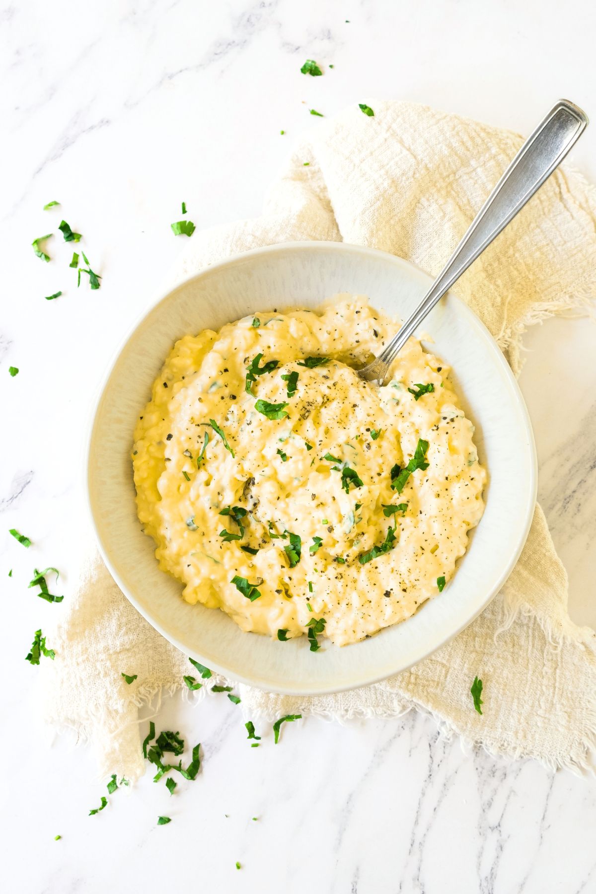 Top down view of a bowl of parsley topped gluten-free egg salad.
