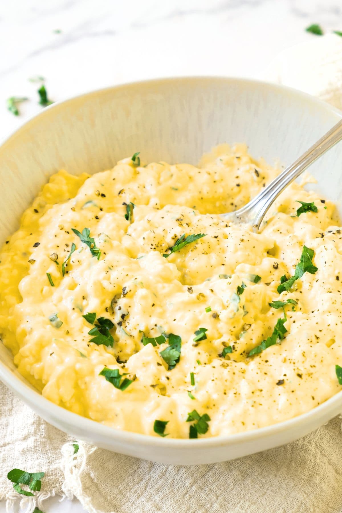 Scooping a spoonful of gluten-free egg salad from a bowl.