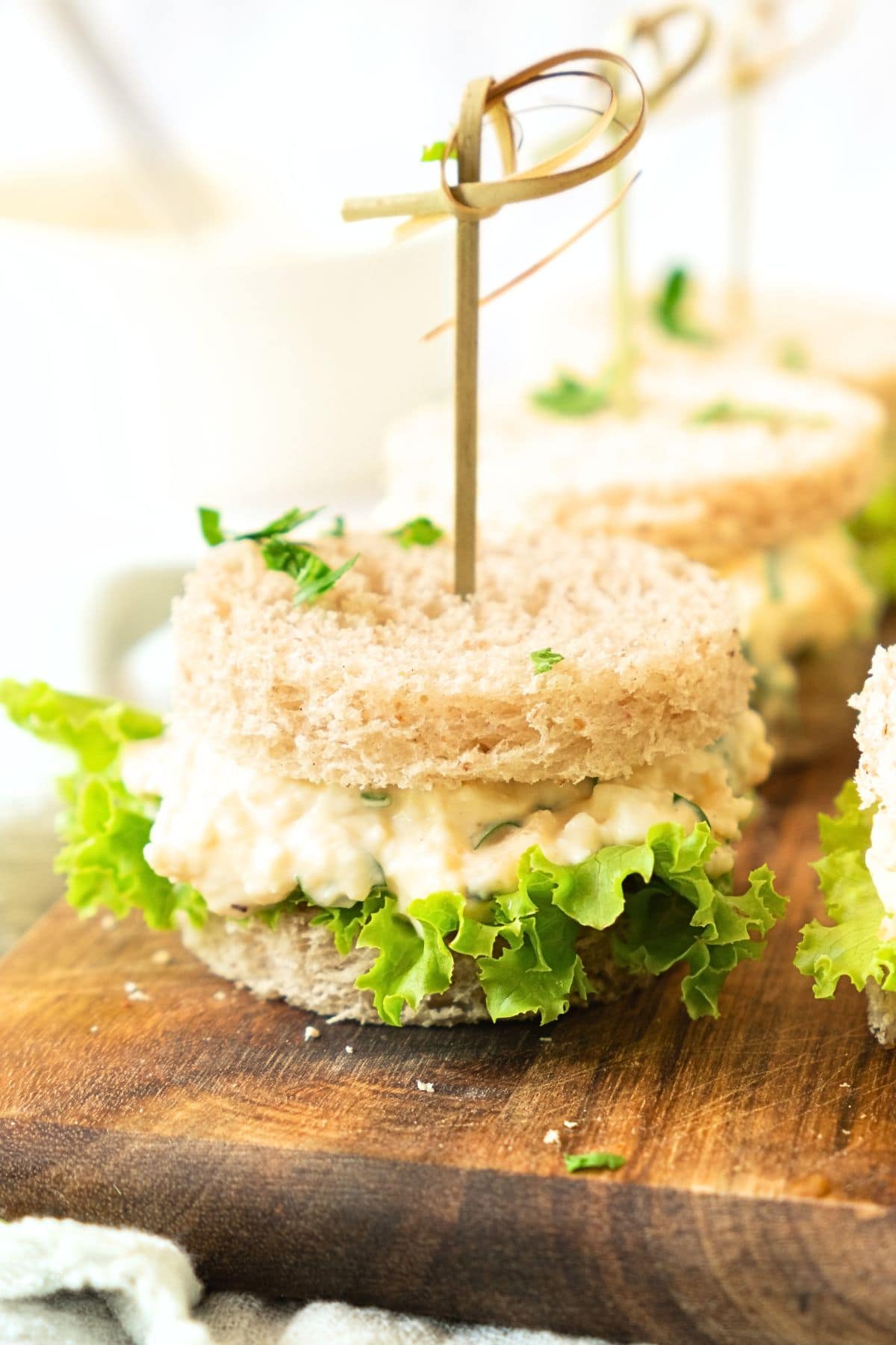 Dairy-free egg salad sandwiches on wooden board.