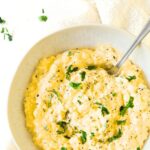 A bowl of egg salad topped with chopped fresh parsley.