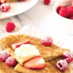 Berries and cream on top of crepes.