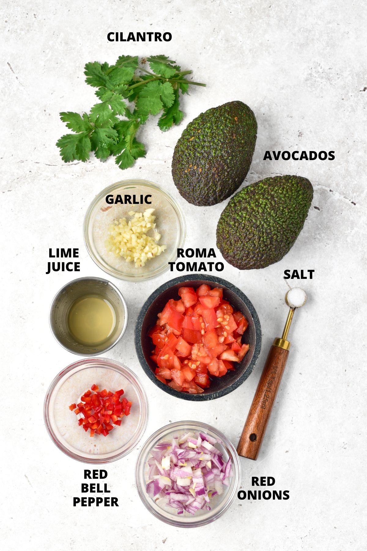 Ingredients for easy guacamole recipe laid out on white board.