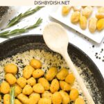 Top down view of a pan with pumpkin gnocchi with rosemary brown butter sauce