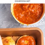 Spreading tomato sauce over cutlets.