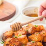 Drizzling honey over crispy air fryer salmon cubes