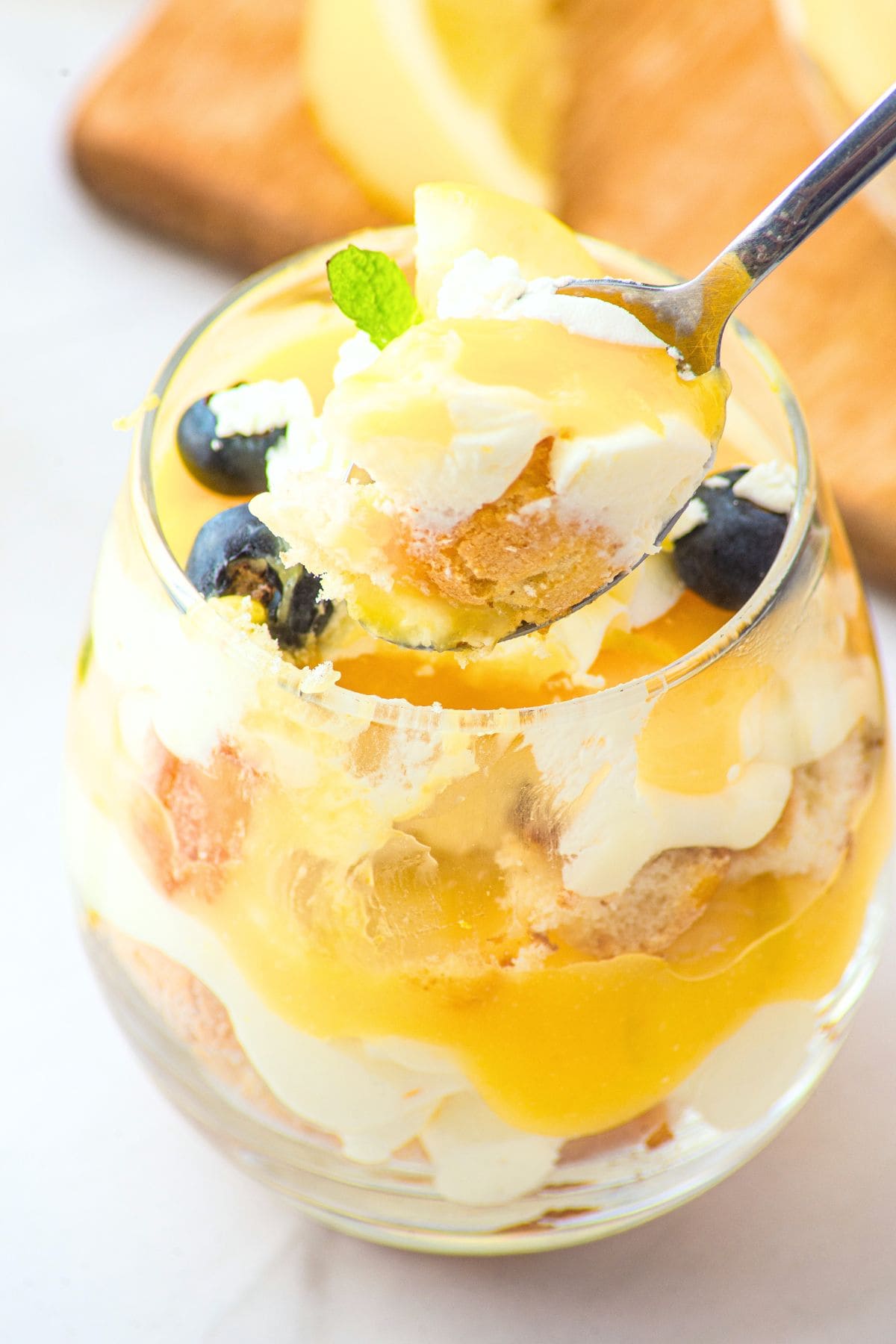 Holding up a spoonful from lemon cheesecake cup