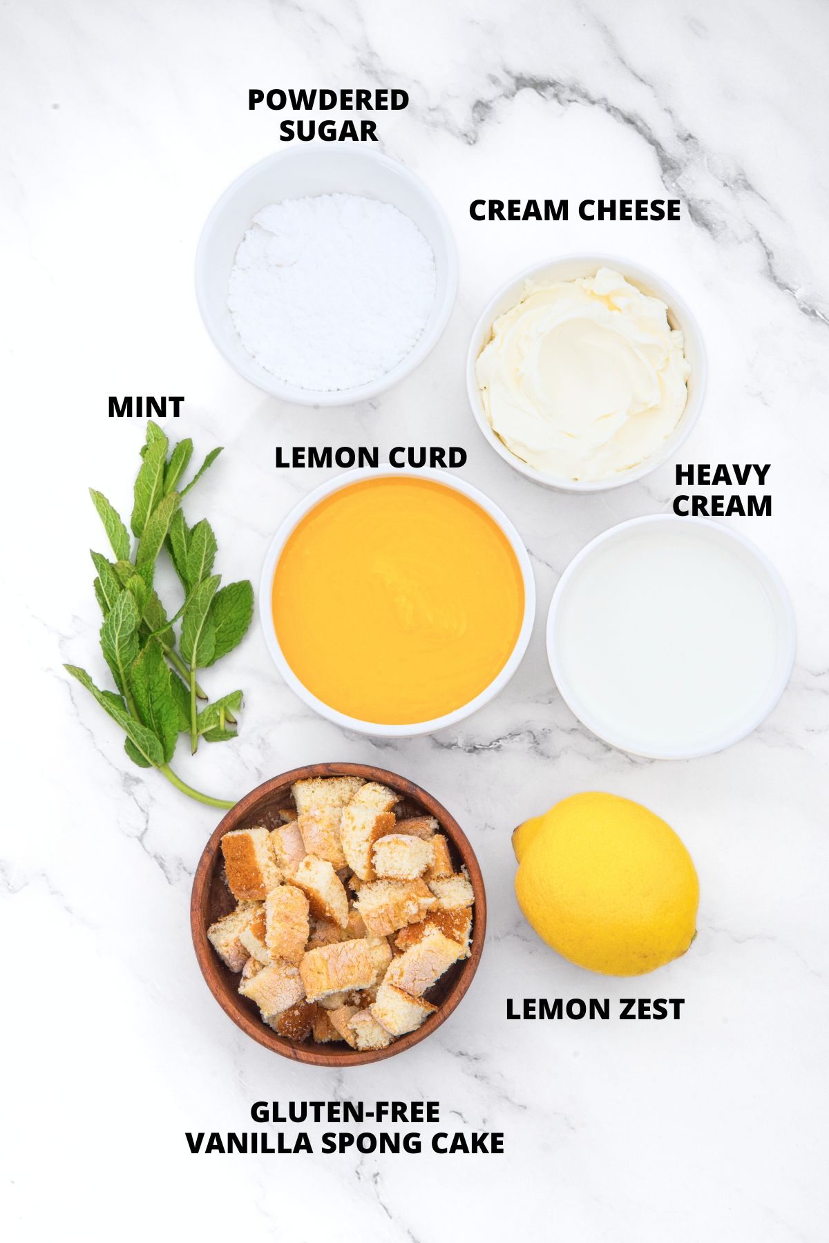 Ingredients for lemon cheesecake cups recipe laid out on marble board