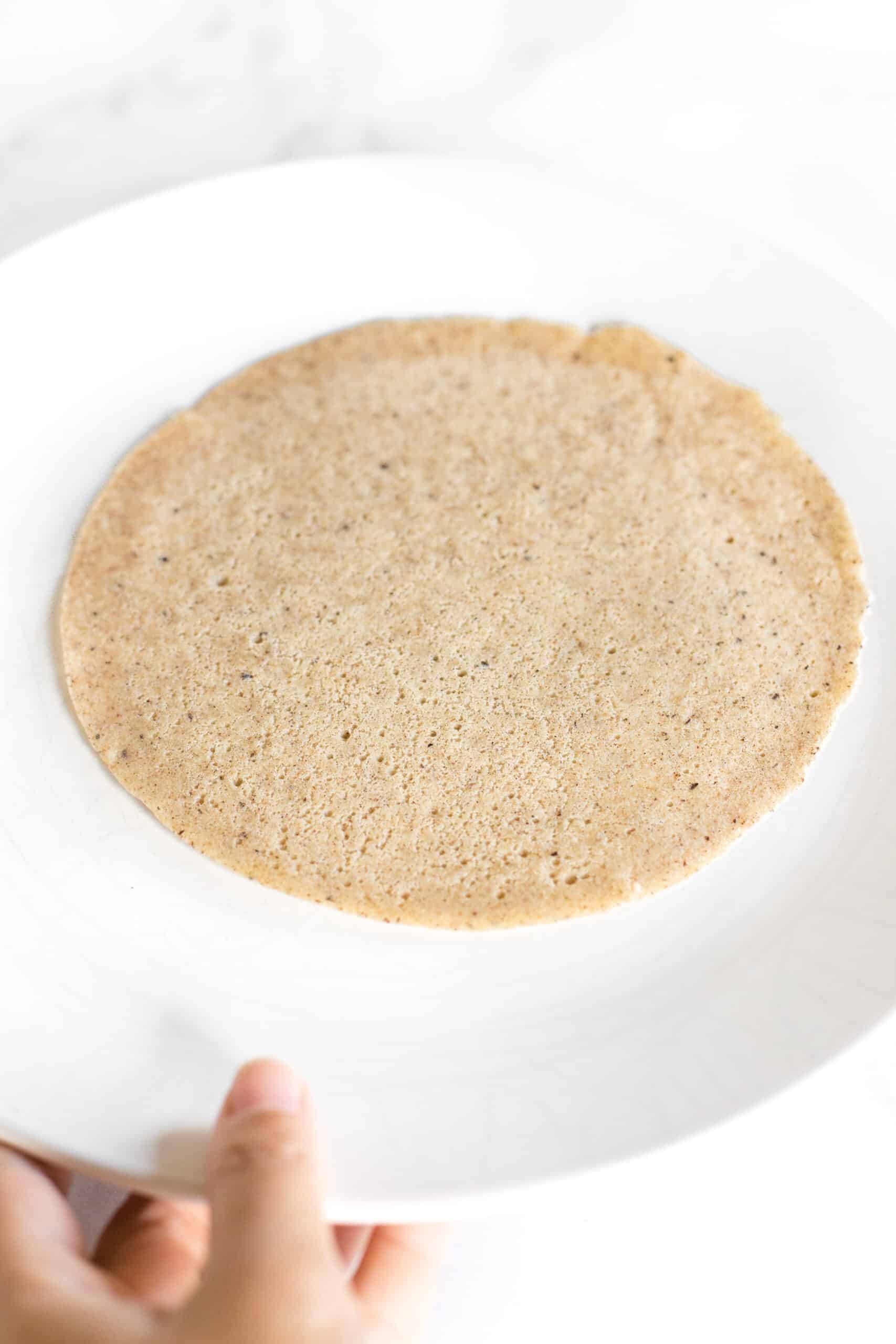 Holding a plate with a single buckwheat crepe.