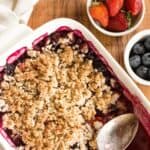 Scooping into a dish of mixed berry crumble.