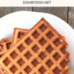 A plate of waffles on a wooden board.
