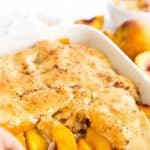 Scooping peaches from a baking dish