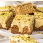 A stack of pistachio cake bars on white plate.