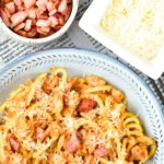 A plate of carbonara pasta topped with pancetta