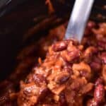 Holding up a ladle of baked beans