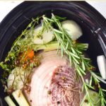 Top down view of ham and veggies in slow cooker