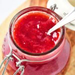 Up close shot of half-opened bottle of strawberry jam