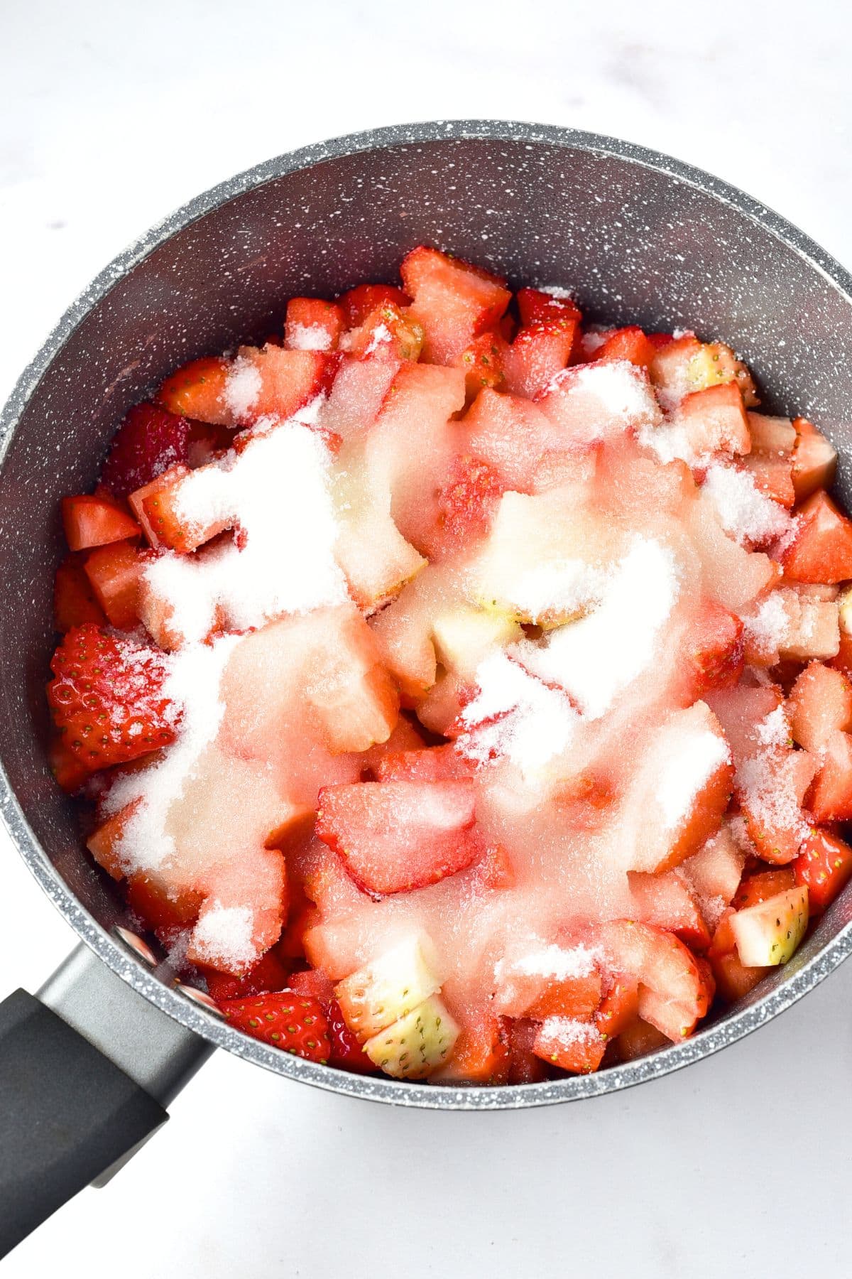 Cut strawberries and sugar in a pot.