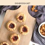 Top down view of almond flour thumbprint cookies on wooden board.