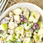 Top down view of a bowl of waldorf salad with apples.
