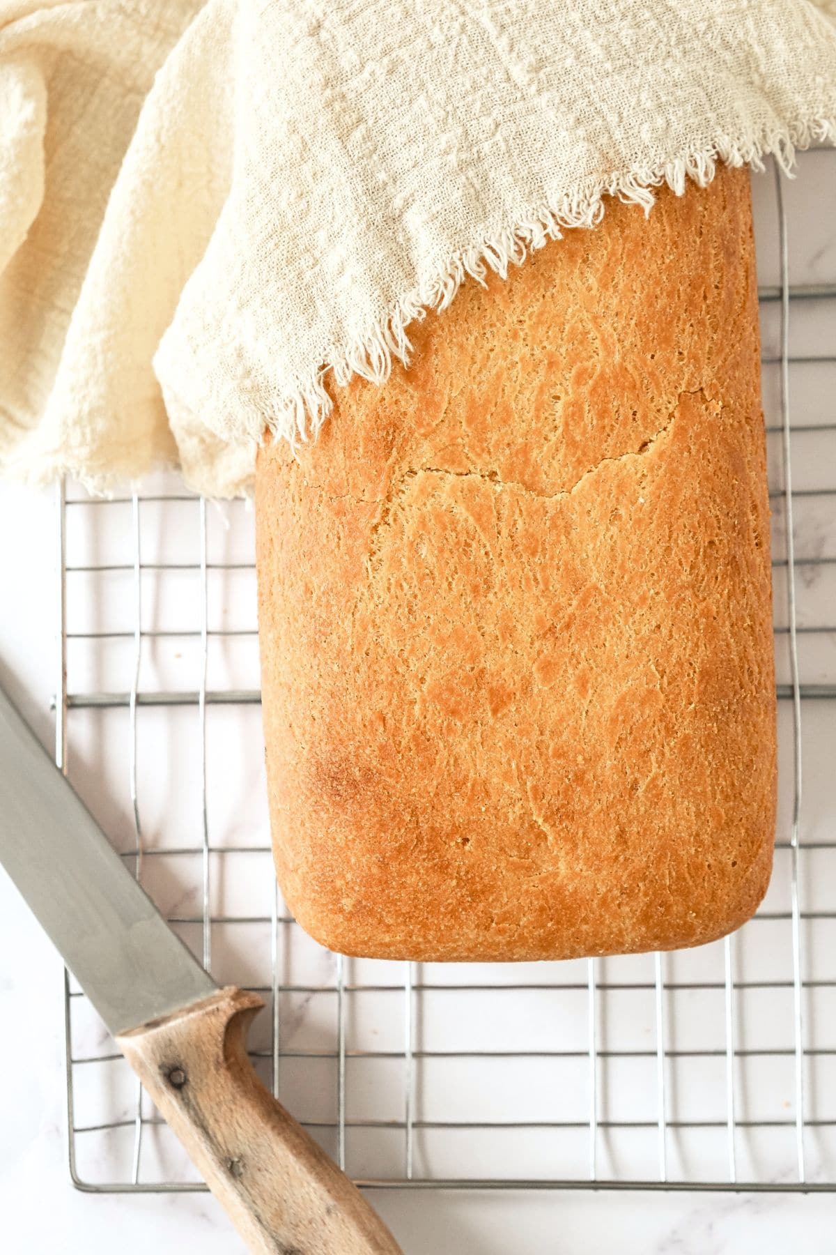 Freshly baked gluten egg-free bread on wire rack.