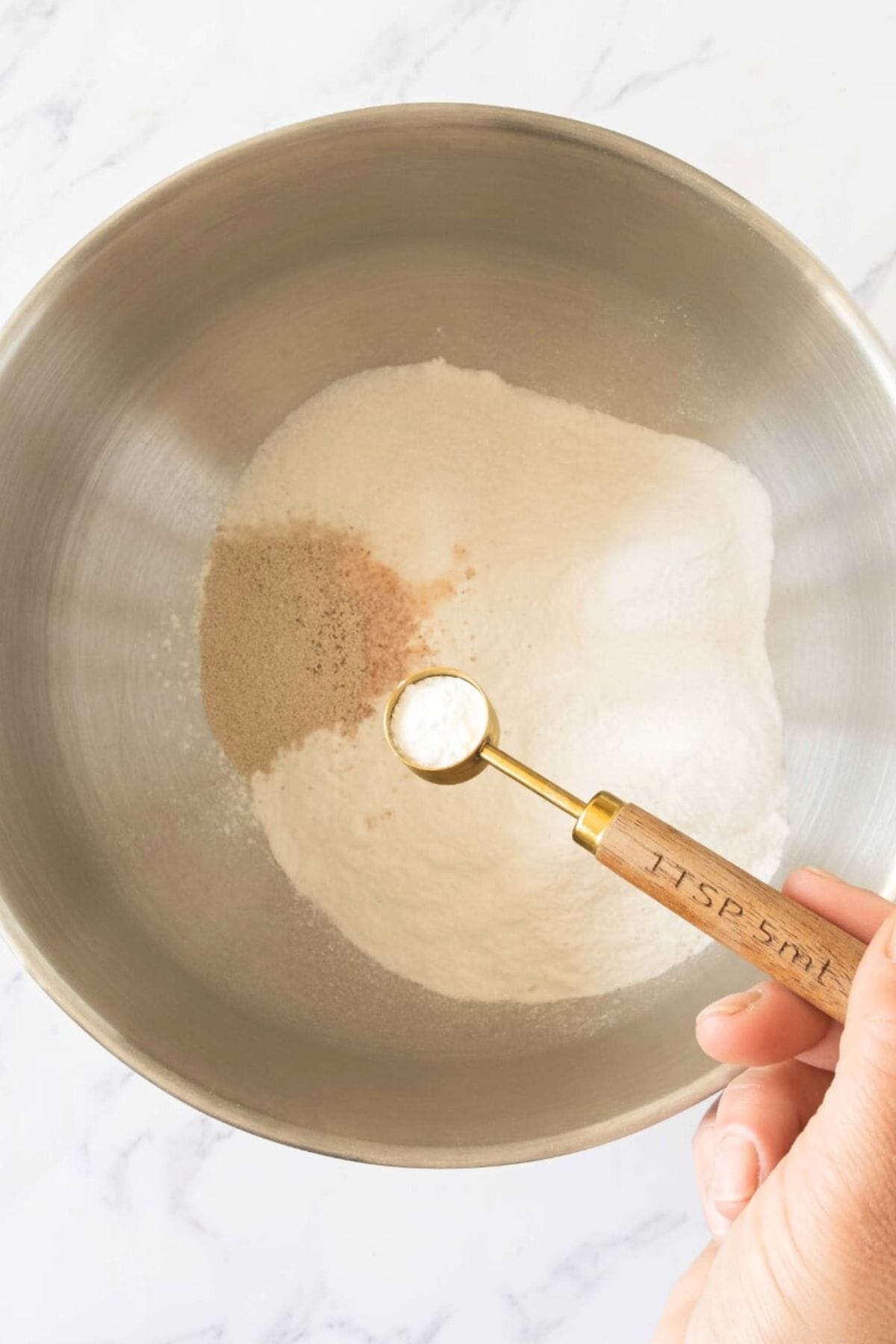 Mixing dry ingredients in metal bowl.
