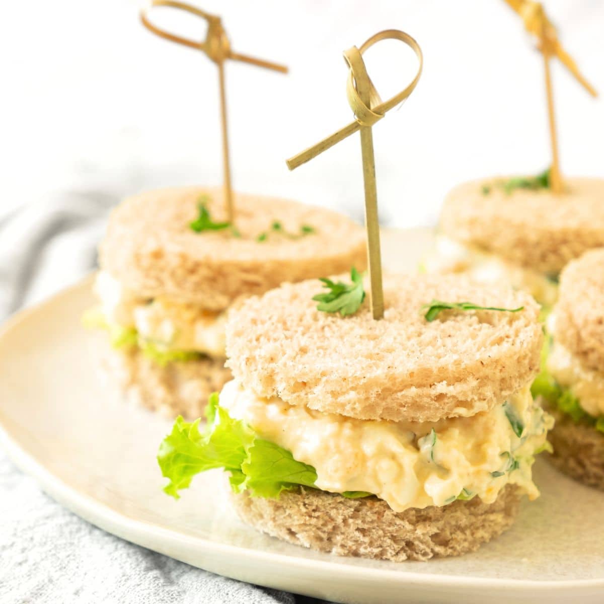 Mini egg salad tea sandwiches on plate