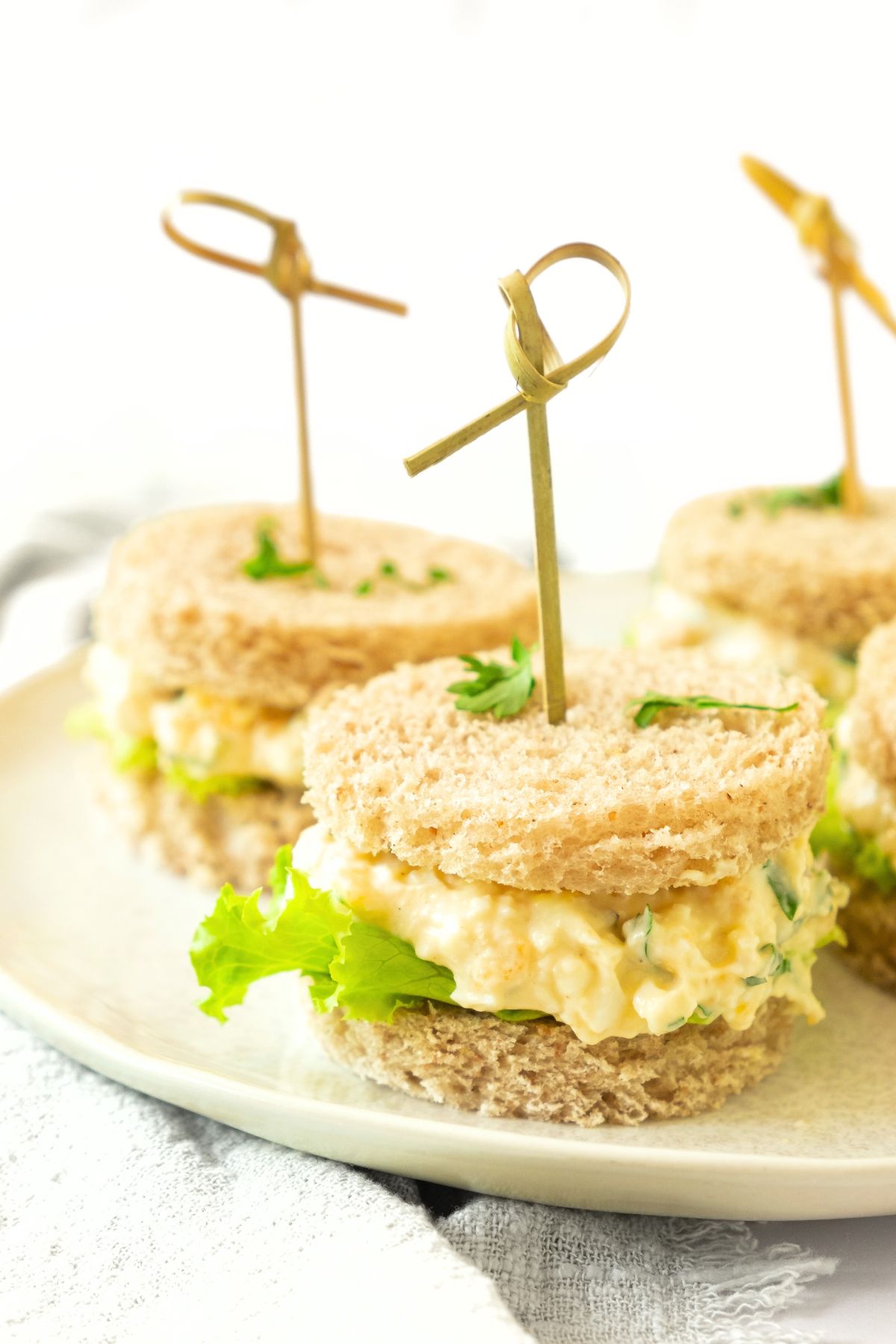 Egg salad tea sandwiches on a plate.