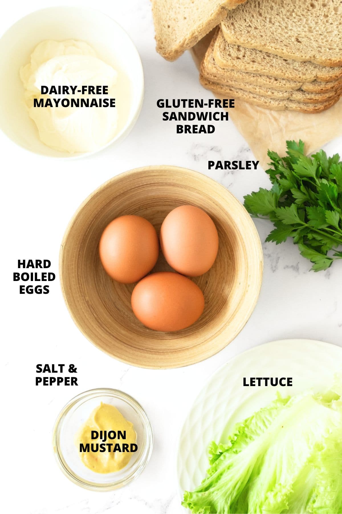 Ingredients for gluten-free egg salad sandwiches recipe laid out on marble board.