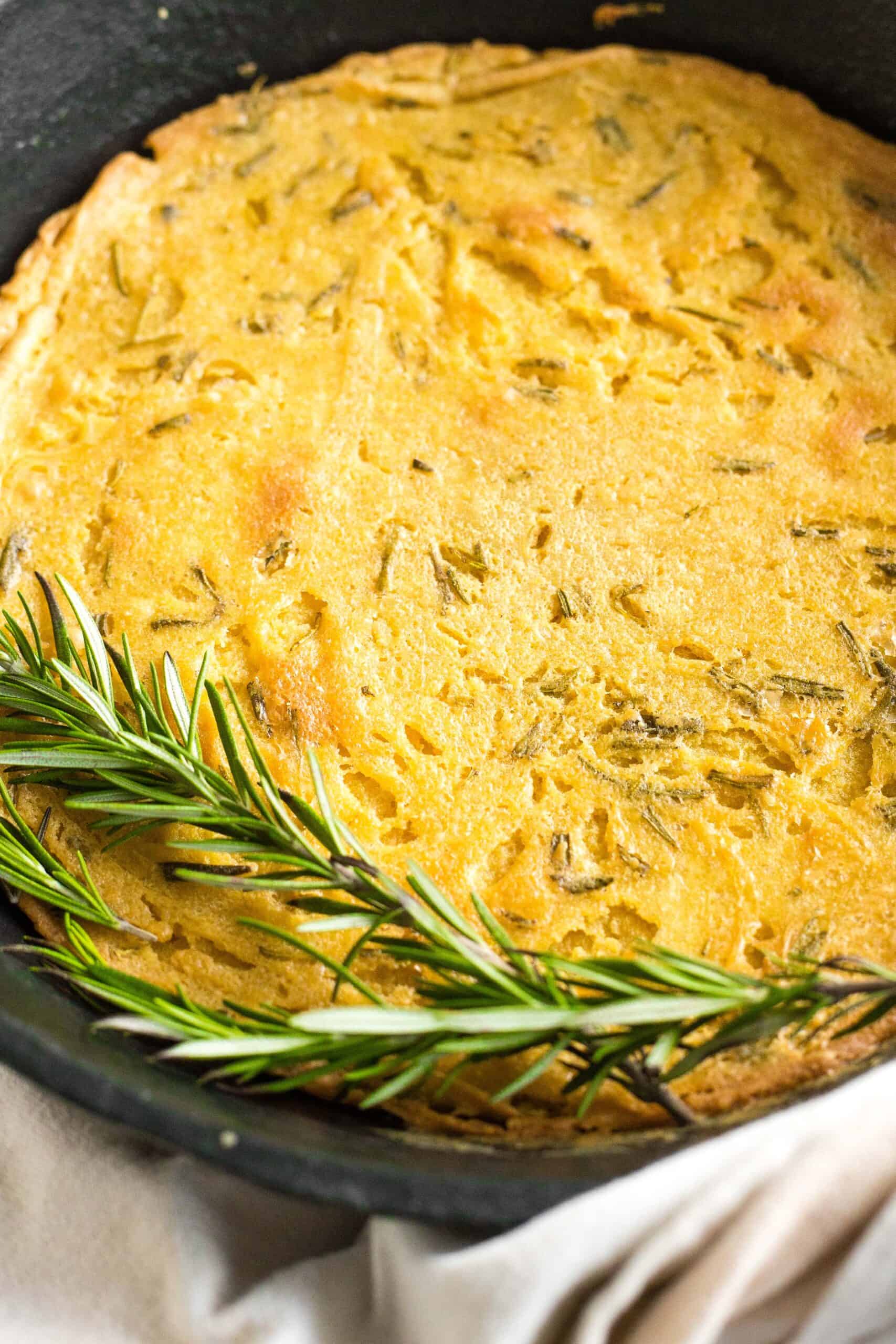 Fresh rosemary on top of a skillet of farinata.