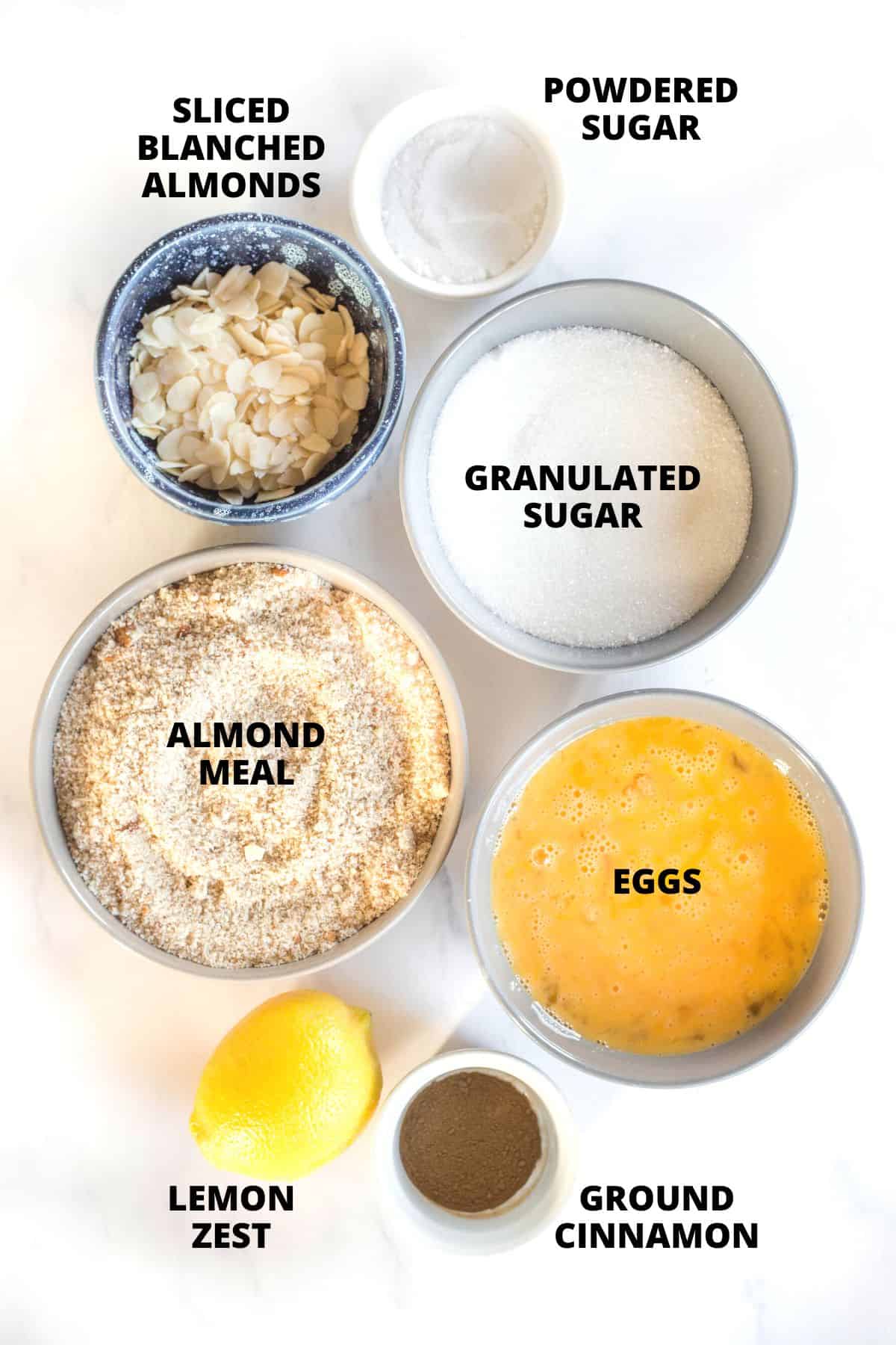 Ingredients for gluten-free almond cake recipe laid out on marble board.