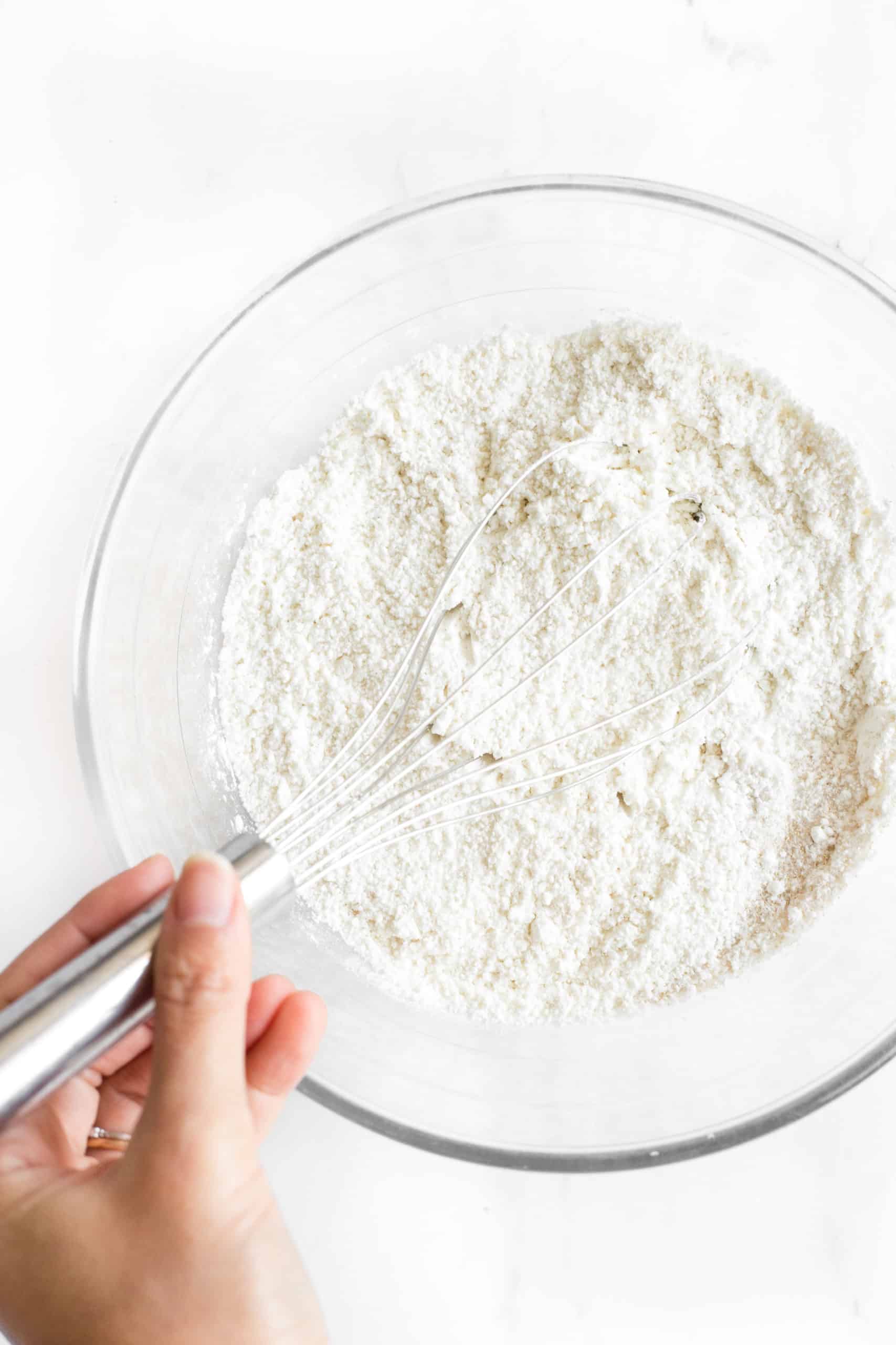Whisking dry ingredients in a mixing bowl.