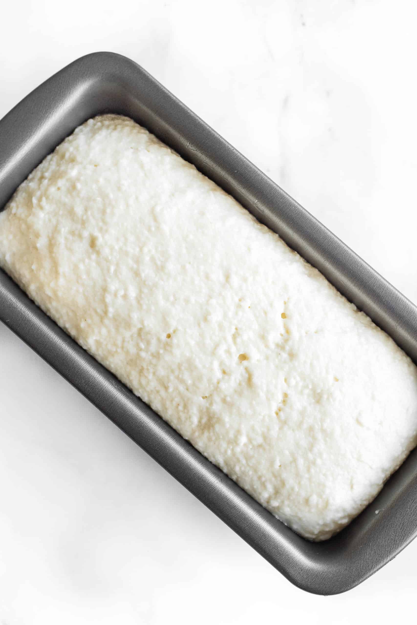Gluten-free bread dough in a loaf pan after rising and doubling in size. 