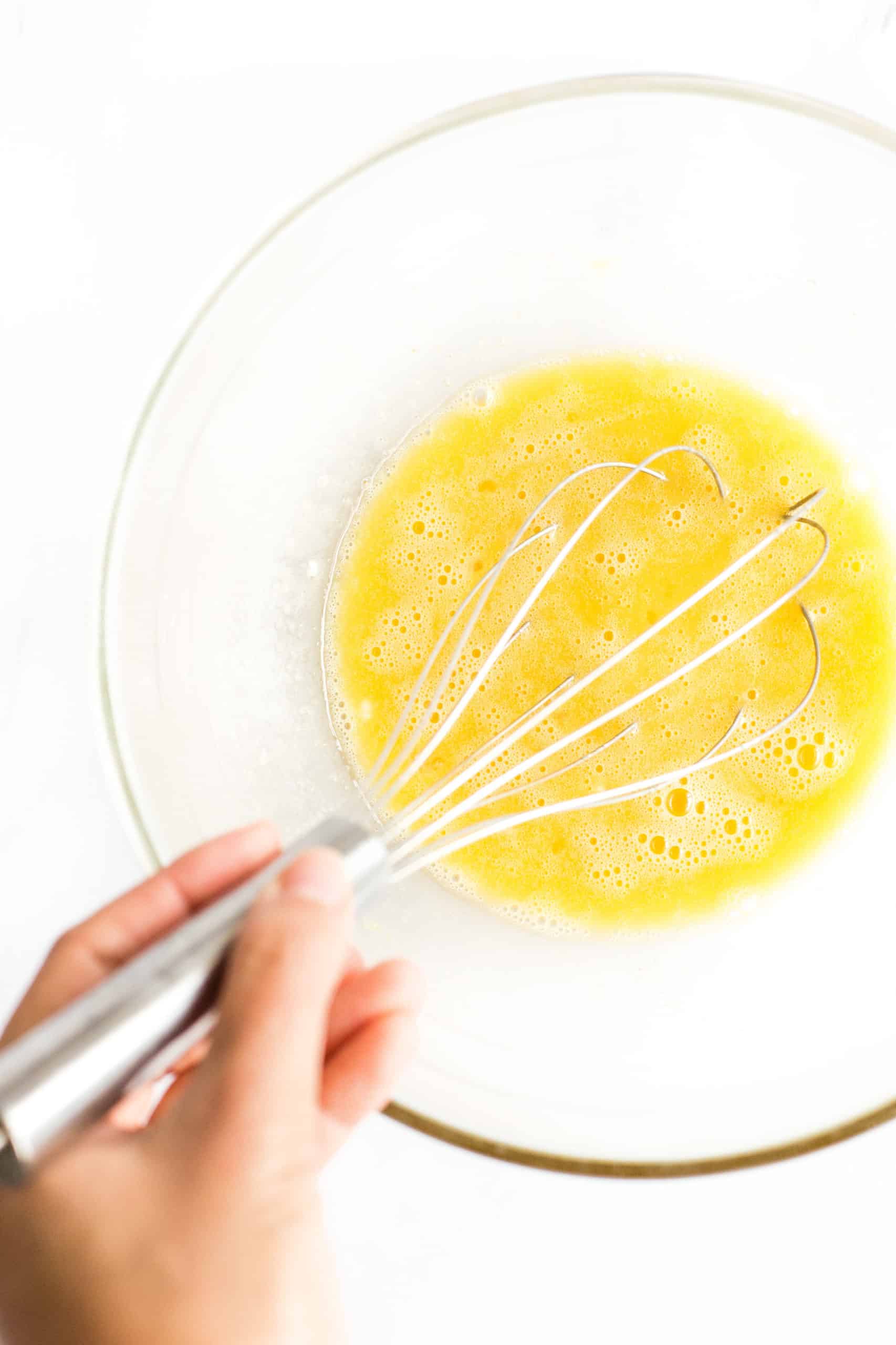 Eggs, sugar, oil, and vanilla whisked in a large mixing bowl. 