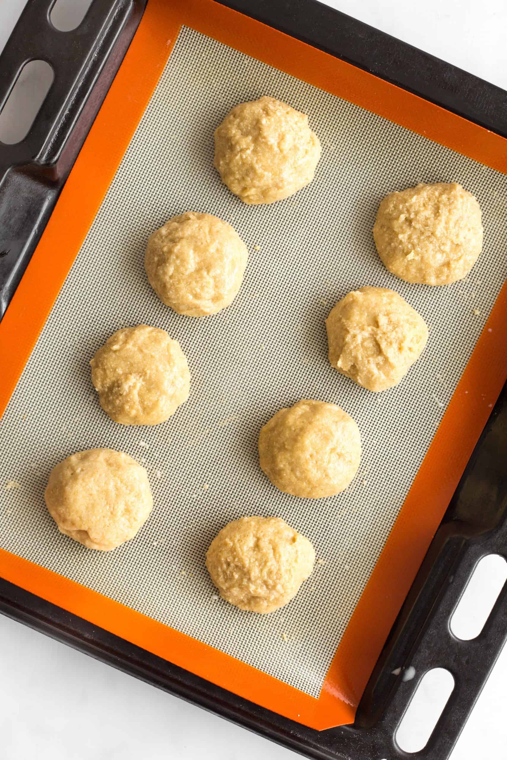Rolls of low carb bread dough on a silpat-lined baking sheet.