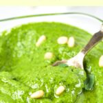 Holding a spoonful of pesto from a bowl
