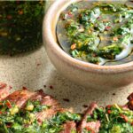 Slices steak topped with chimichurri