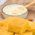 A place of cornbread squares in front of a bowl of almond flour.