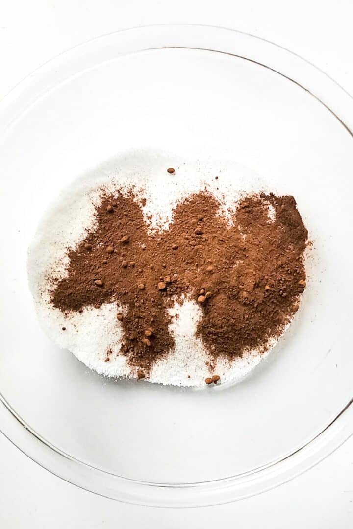 Sugar and ground cinnamon in glass mixing bowl.
