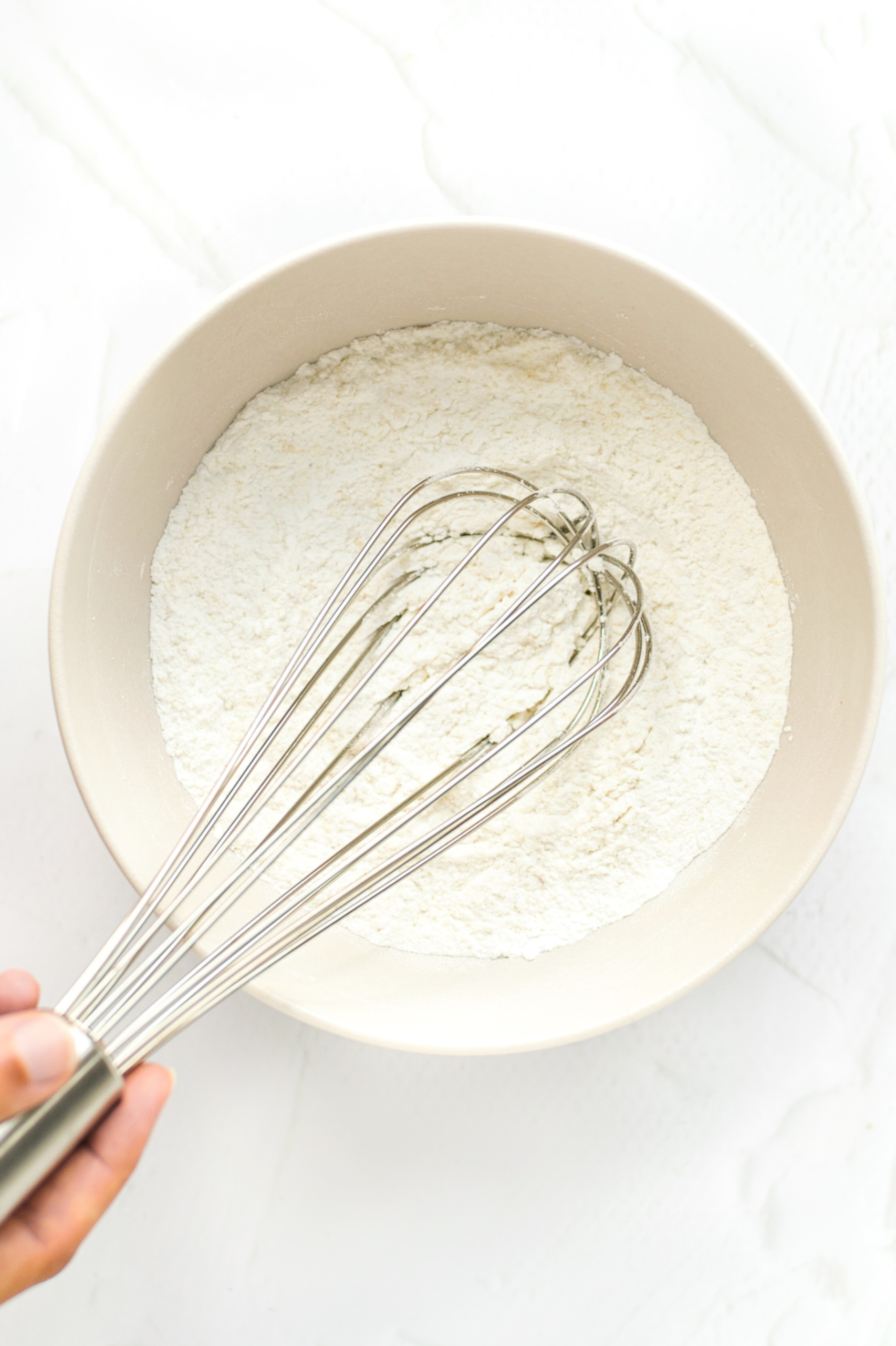 Whisking flour mixing in large mixing bowl.