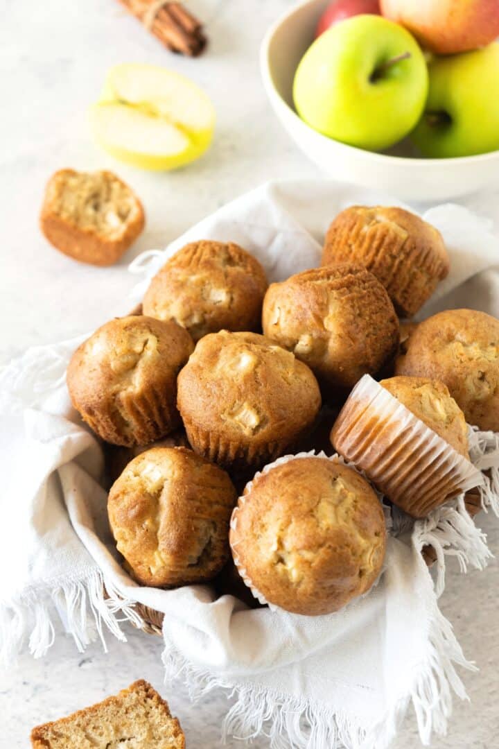 Gluten-free apple muffins in basket with kitchen towel.